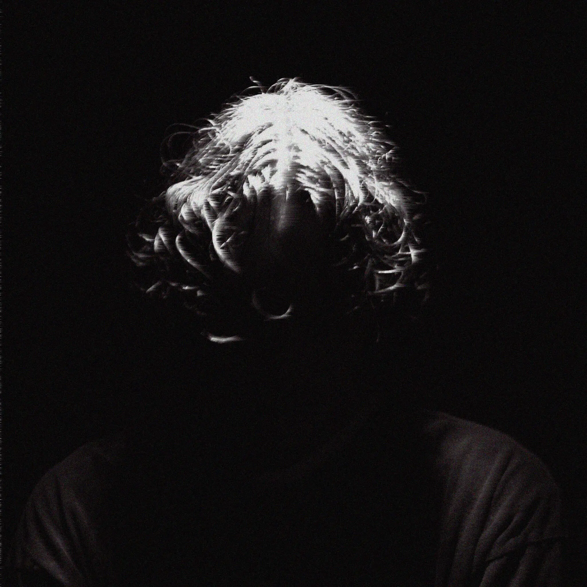 head shot of man illuminated face under light with black ground